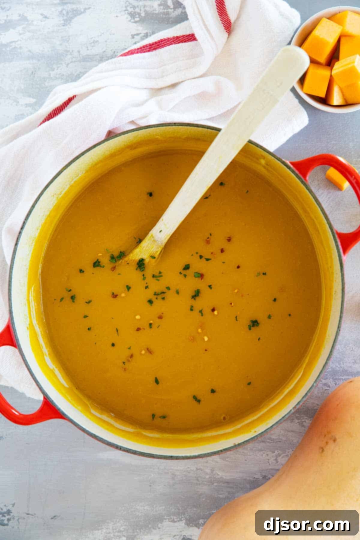 A large pot of creamy Curried Butternut Squash Soup, steaming gently, ready to be served.