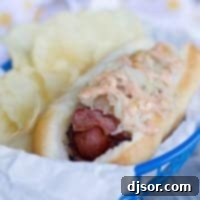 The Ultimate Pastrami Hot Dog 2 Pastrami Wrapped Hot Dog in a basket, highlighting the melted cheese and dressing.