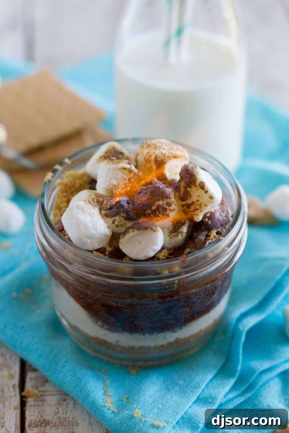 S’mores without the campfire! These Peanut Butter S’mores have a graham cracker crust, lots of marshmallow, rich chocolate and a peanut butter drizzle – all served in a jar. Peanut Butter S'mores in a Jar with toasted marshmallows