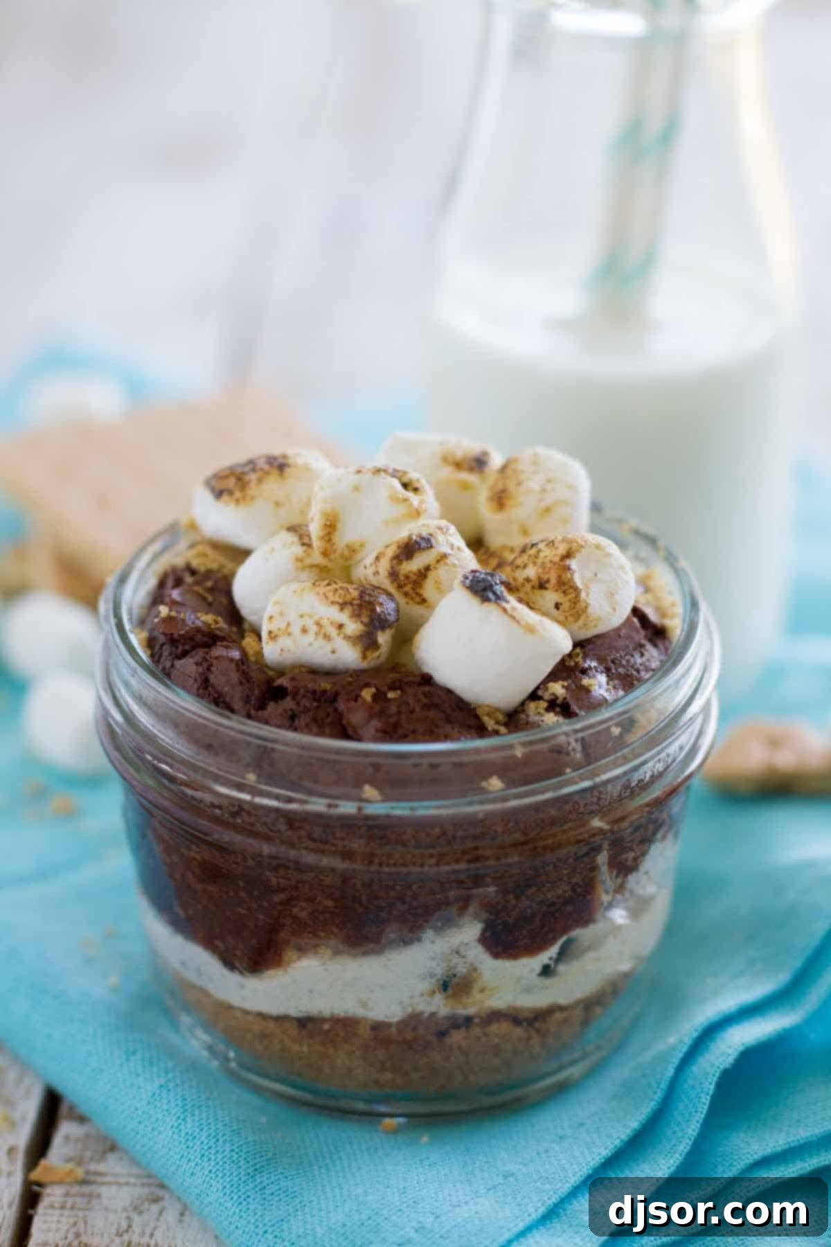 S’mores without the campfire! These Peanut Butter S’mores have a graham cracker crust, lots of marshmallow, rich chocolate and a peanut butter drizzle – all served in a jar. Jar with Peanut Butter S'mores topped with charred marshmallows and a spoon