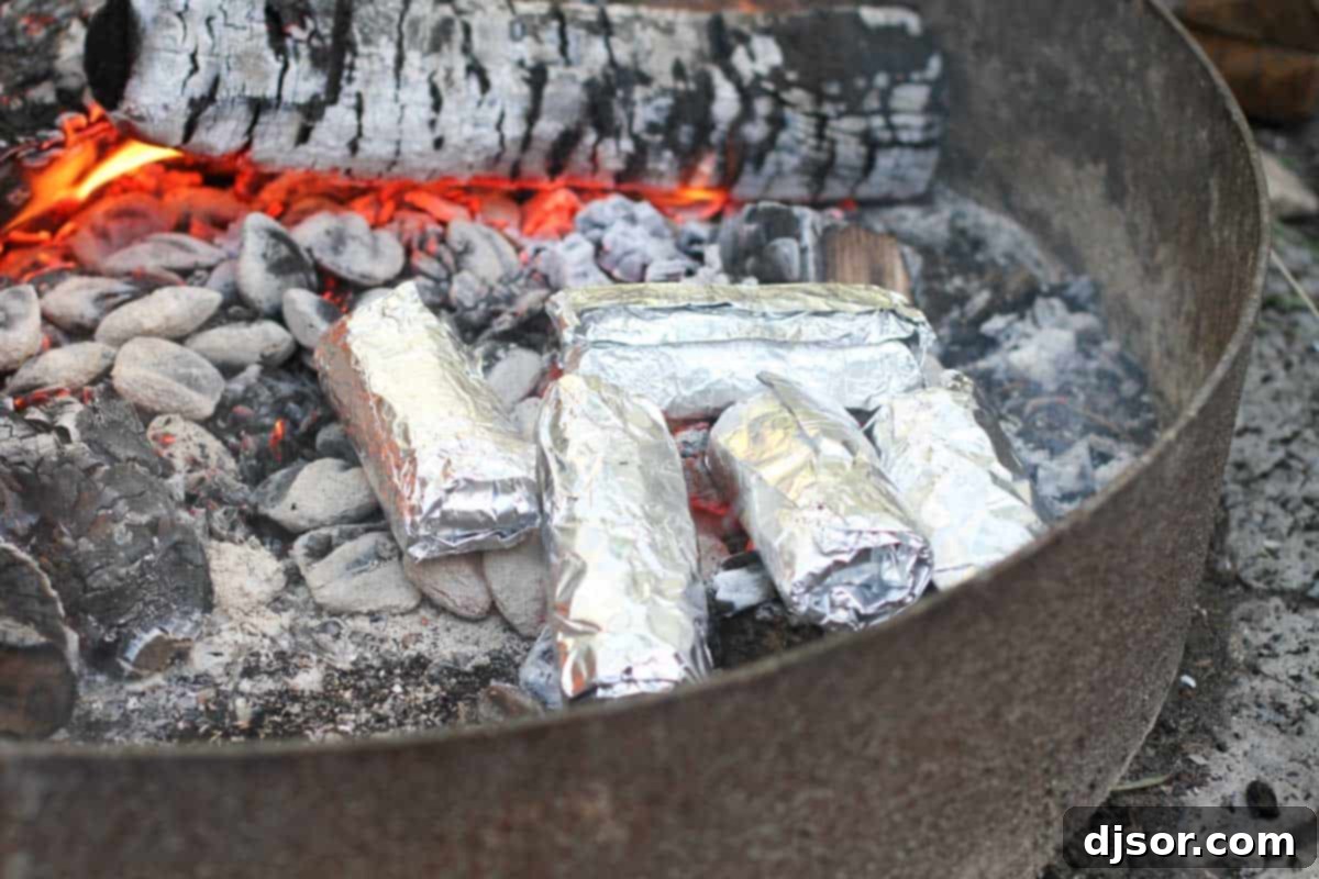 A close-up of the cooked filling for breakfast burritos, showing scrambled eggs, ham, hash browns, and cheese in a skillet.