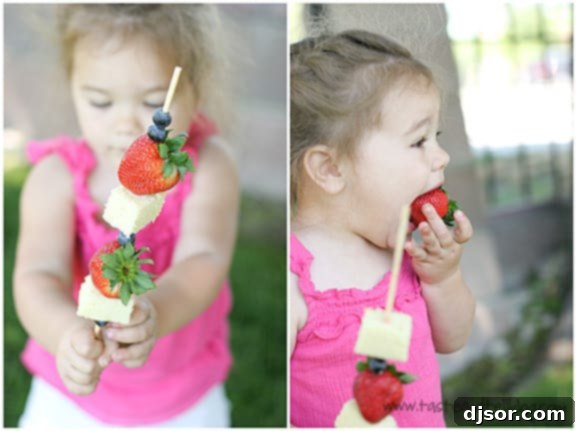 A young girl happily eating a 4th of July Dessert Kabob, showcasing the enjoyment of this simple and delicious patriotic treat.