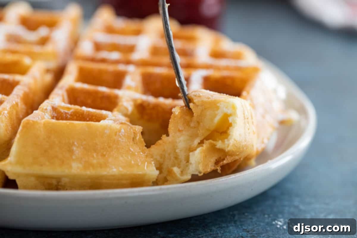Close-up shot showing the light and fluffy interior texture of a freshly baked waffle, indicating its perfect consistency.