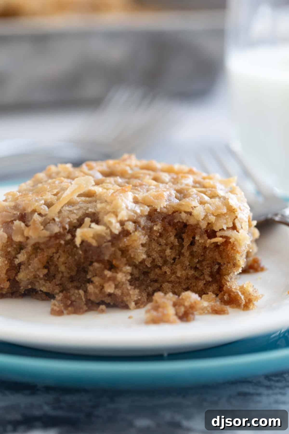 Spiced Oatmeal Delight 8 Oatmeal Cake with a forkful taken from it, revealing the moist interior and coconut topping.