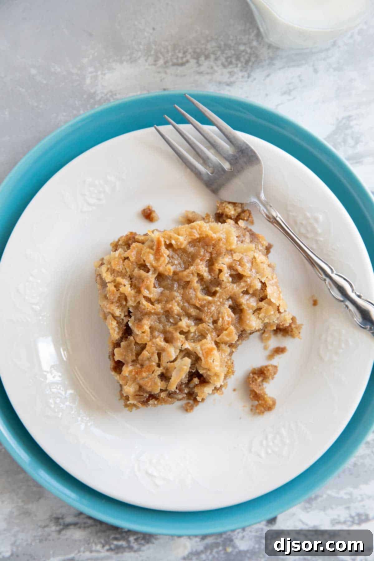 Spiced Oatmeal Delight 9 Close-up slice of oatmeal cake on a plate with a bite taken, showcasing the moist texture and topping.
