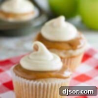 Decadent Caramel Apple Cupcakes 3 Caramel Apple Cupcakes with more cupcakes and apples in the background