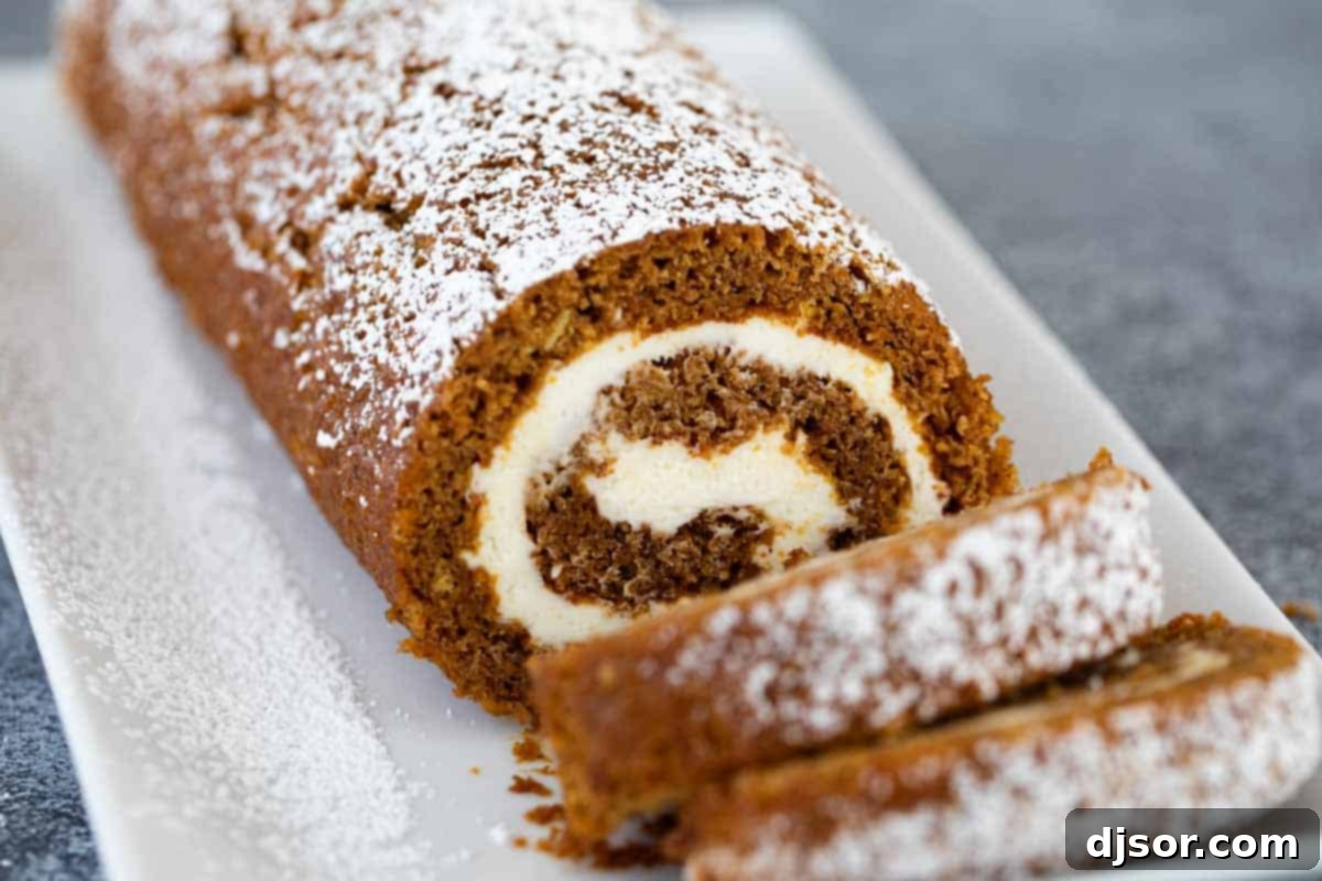 Sliced pumpkin roll dusted with powdered sugar, ready to serve.