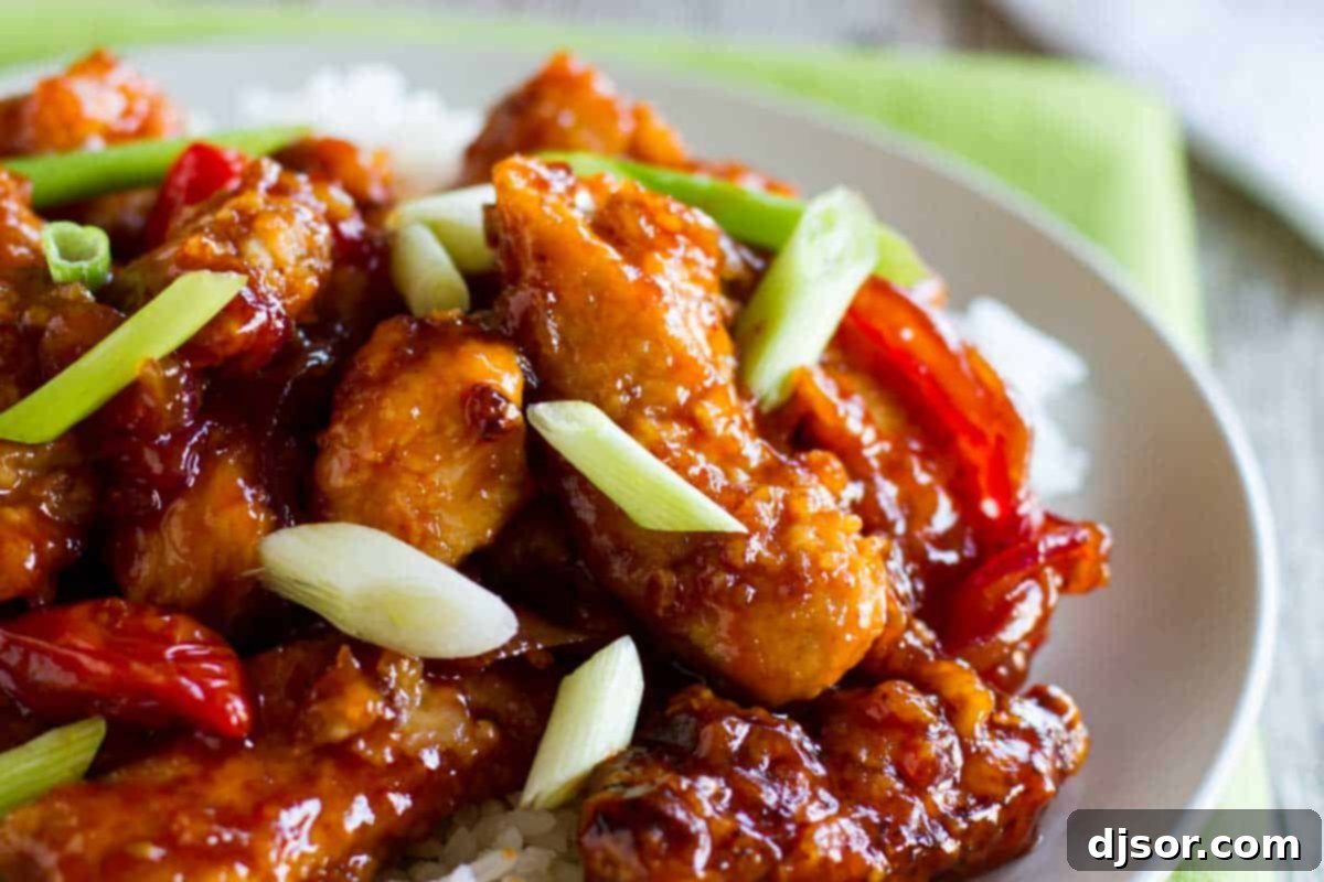 Wok-Kissed Chicken Delights 2 Crispy Chinese Chicken served on a plate with fresh green onions and sesame seeds, ready to be enjoyed with rice.