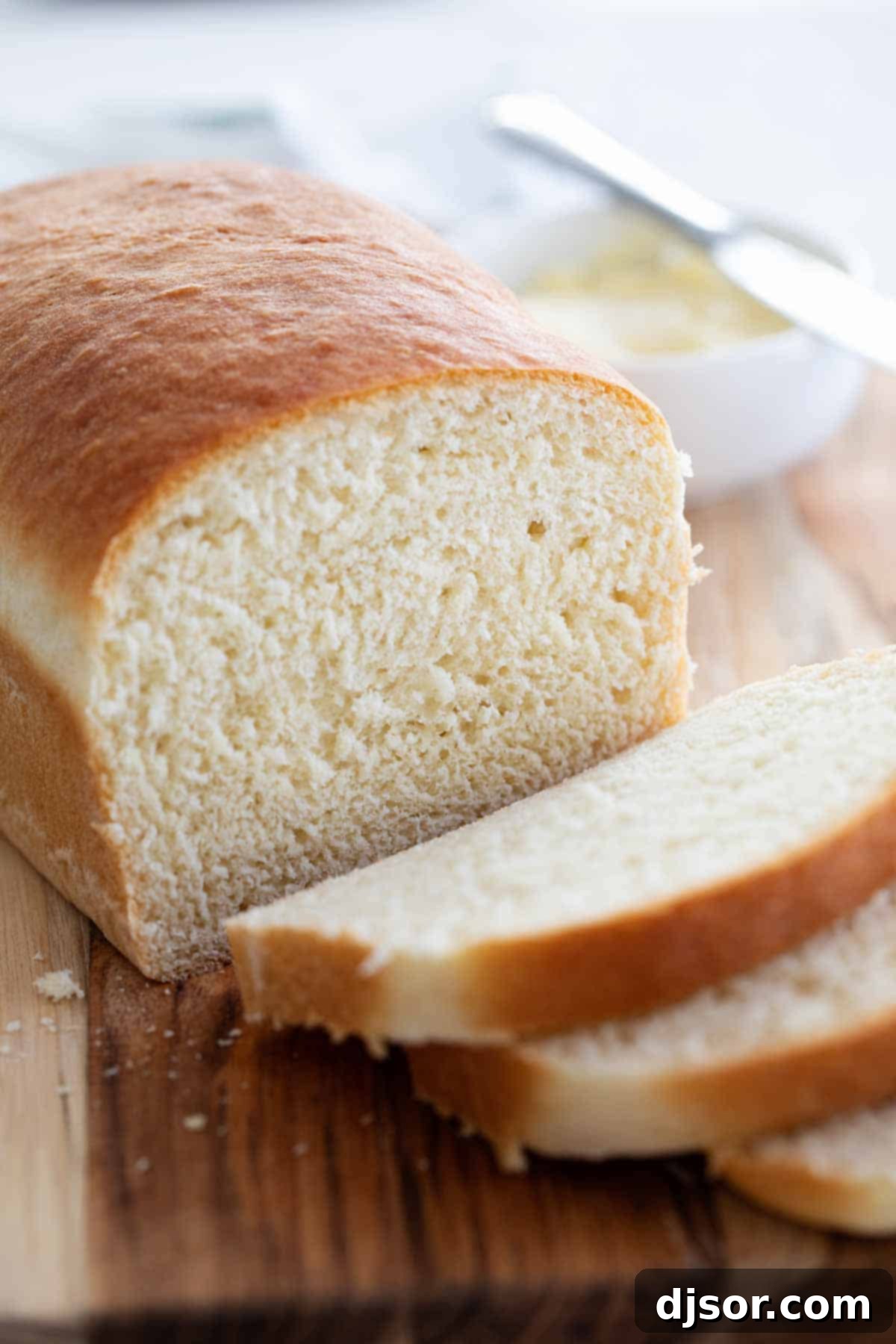 Made from scratch, this Homemade White Bread Recipe is perfect for sandwiches, toast, or simply with butter and jam. You won’t believe just how easy it is! Perfectly sliced homemade white bread on a cutting board, ready for serving.