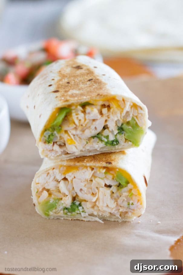 Close-up of a delicious grilled chicken and broccoli burrito, cut in half to show the cheesy filling.