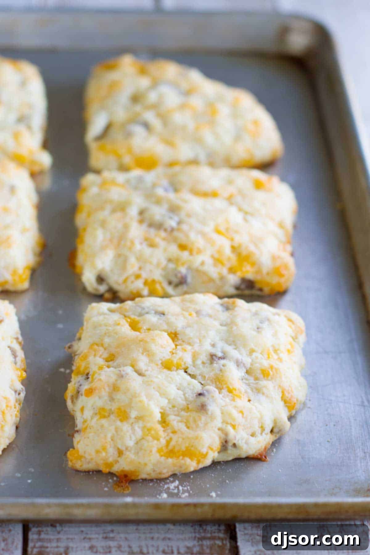 Cheddar Sausage Biscuits: A Southern Comfort Twist 2 Fluffy Cheddar Sausage Biscuits arranged on a baking tray, ready for a delicious breakfast.