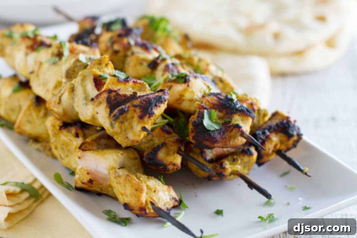 Stack of vibrant Grilled Indian Chicken Skewers, perfectly charred and seasoned.