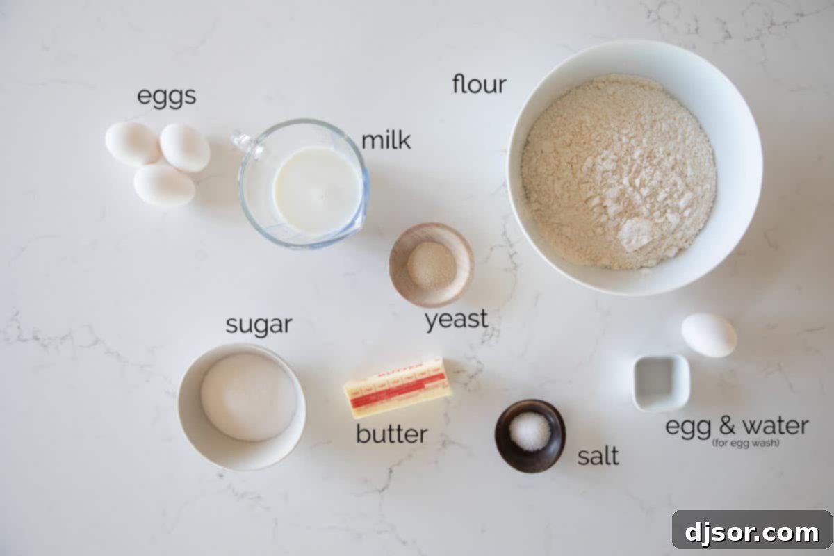 Assorted brioche ingredients including milk, yeast, eggs, sugar, butter, salt, and flour, neatly laid out on a clean kitchen counter, ready for the baking process.