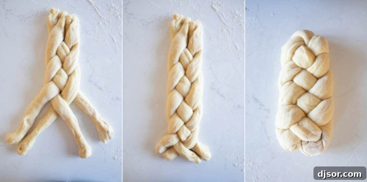 Hands carefully braiding four strands of soft brioche dough on a lightly floured surface, midway through the intricate weaving process.