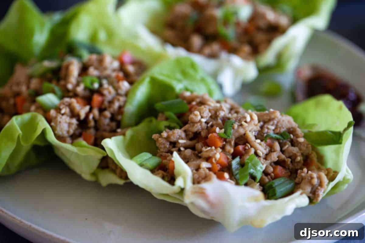 chicken lettuce wraps on a plate topped with green onions