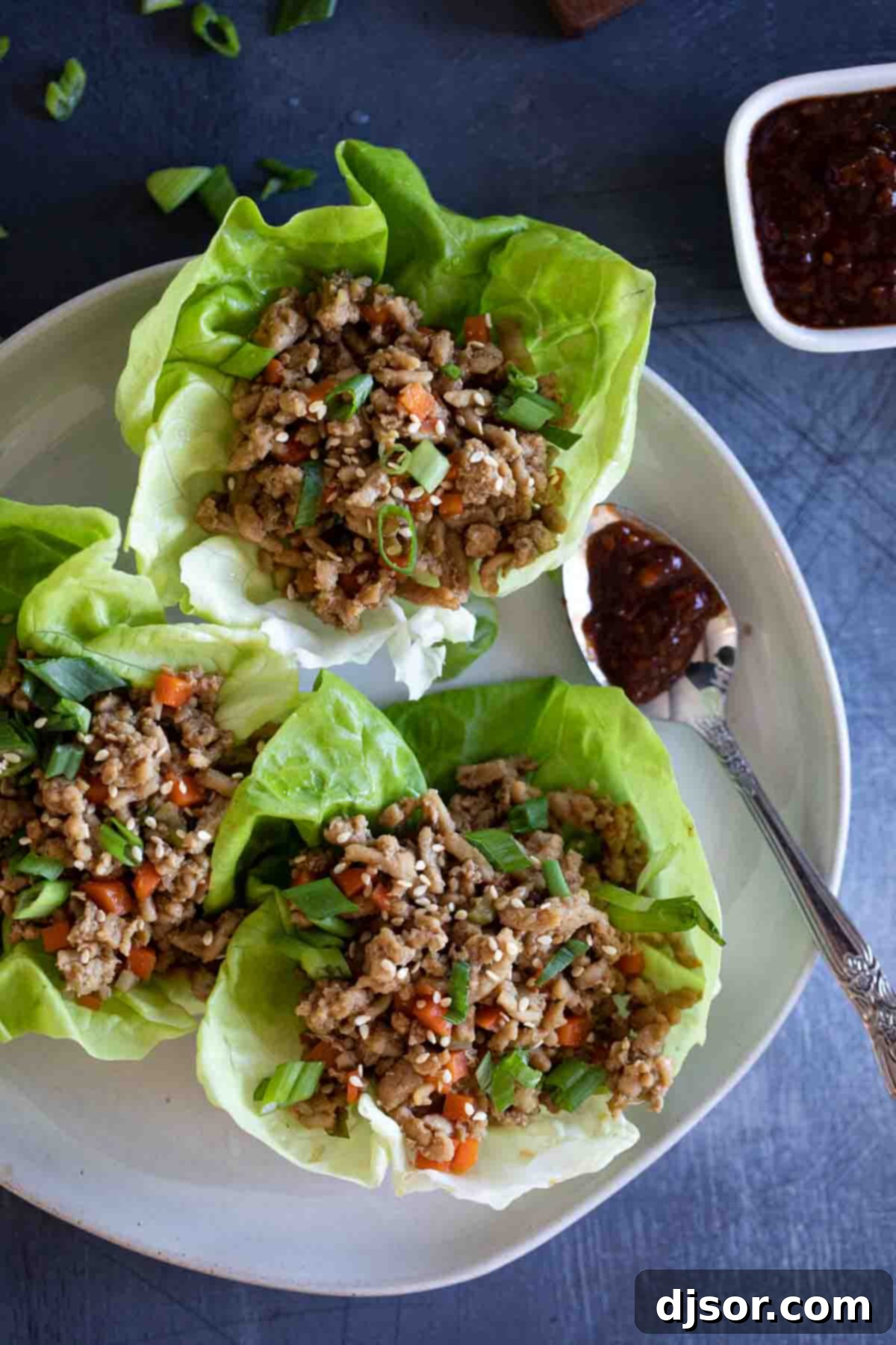 overhead view of chicken lettuce wraps with chili sauce