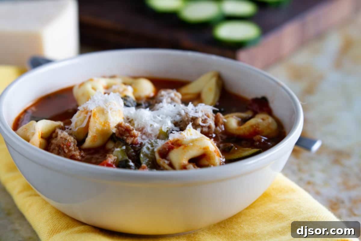 A steaming bowl of hearty Sausage Tortellini Soup, garnished with fresh herbs, ready to be enjoyed.