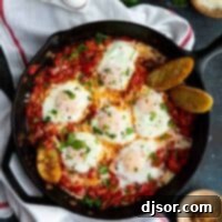 Cast iron skillet with eggs poached in tomato sauce for shakshuka