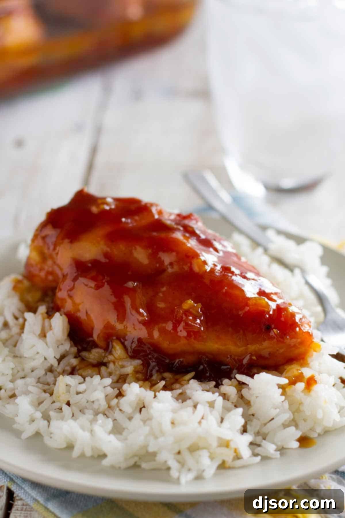 Caramelized Chicken Perfection 2 A glistening piece of Candied Chicken served elegantly over a bed of fluffy white rice, showcasing the rich, sweet, and tangy sauce.