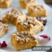 Freshly baked pumpkin pie bars arranged on parchment paper on a baking tray, ready to cool and be sliced.