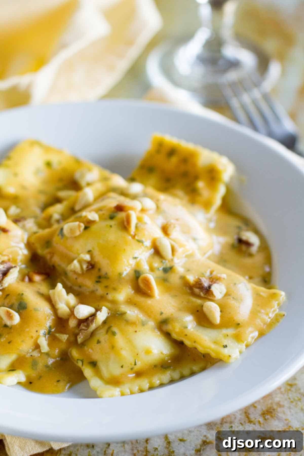 Ravioli with Pumpkin Pasta Sauce: The Ultimate Fall Comfort Food A bowl of ravioli generously topped with creamy pumpkin pasta sauce, garnished with fresh herbs and toasted nuts, highlighting a comforting fall dinner.