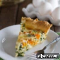 Savory Butternut Squash and Kale Quiche 2 Slice of butternut squash quiche with kale with a fork on a plate.