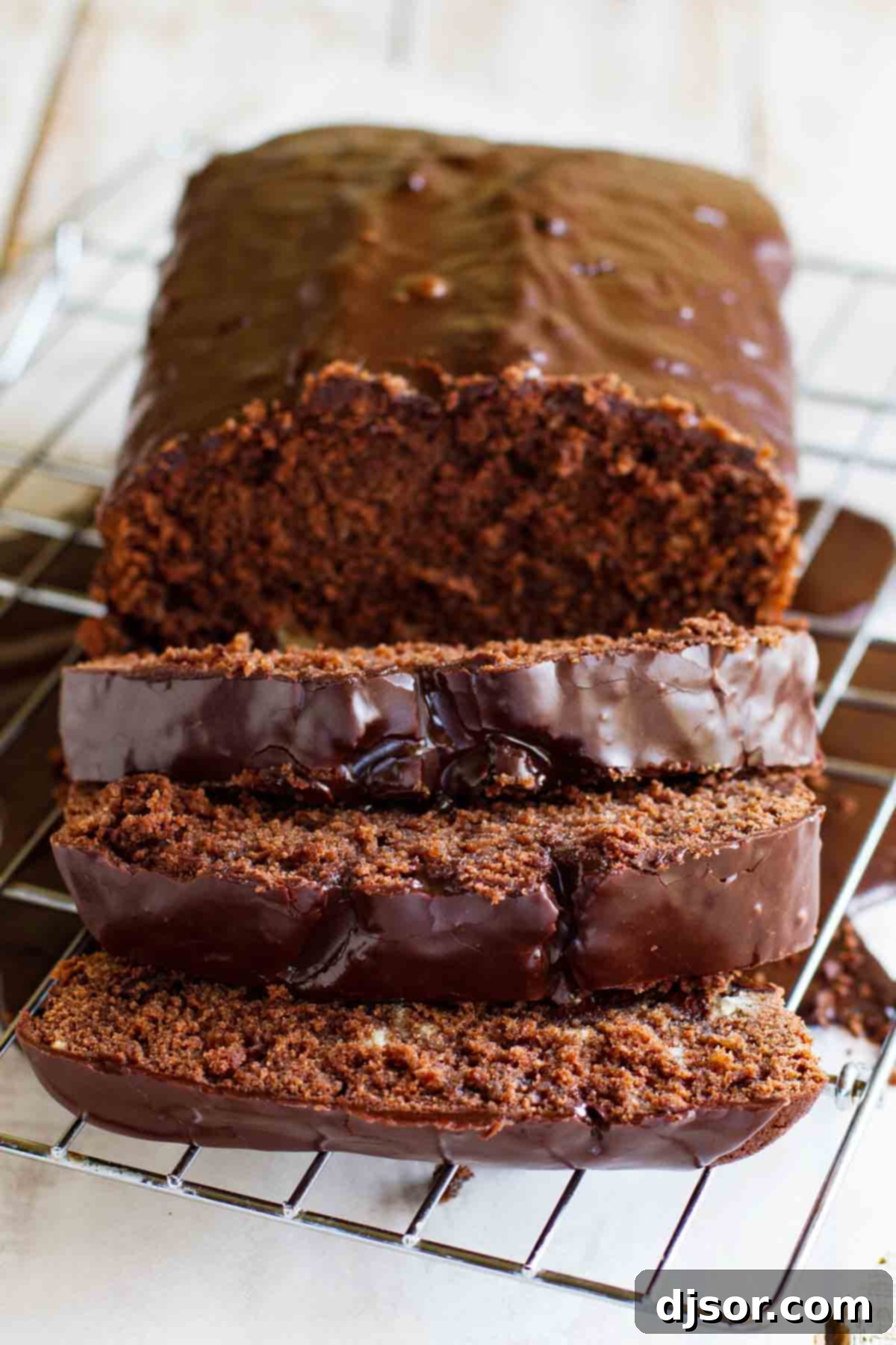 A perfectly baked, dark chocolate pound cake loaf, showcasing its rich brown crust and inviting texture, ready for glazing.