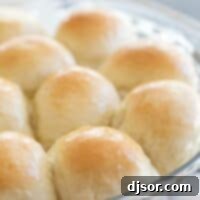 Dinner rolls with butter on top in a round dish, ready to be served.