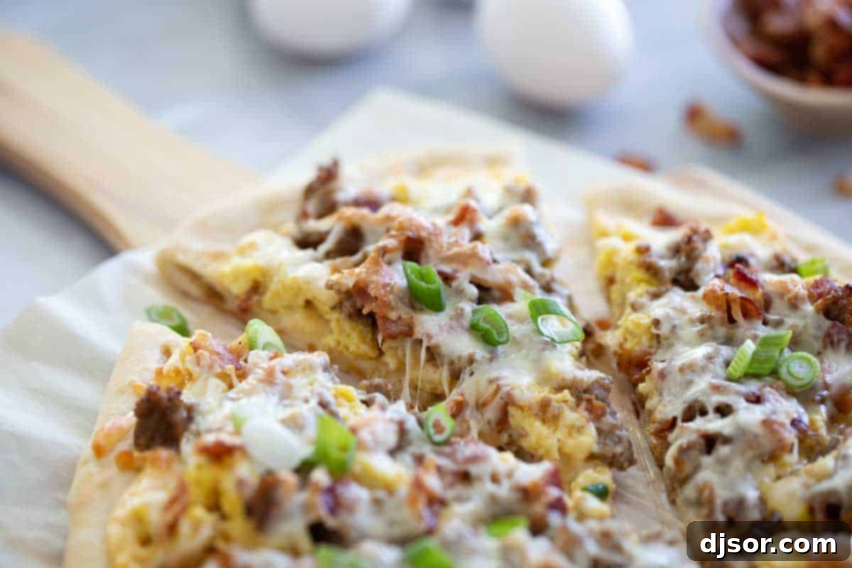 Breakfast Pizza with Sausage, Bacon, Eggs, and Cheese Sauce Perfect for breakfast or dinner, this Breakfast Pizza is topped with sausage, bacon, eggs, and an easy cheese sauce. This is a great way to do something different for pizza night! Sliced breakfast pizza on parchment paper ready to serve.