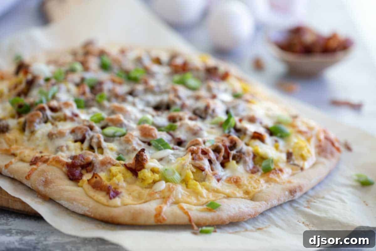 Baked Breakfast Pizza Whole finished breakfast pizza, golden brown with melted cheese, sausage, bacon, and eggs visible.