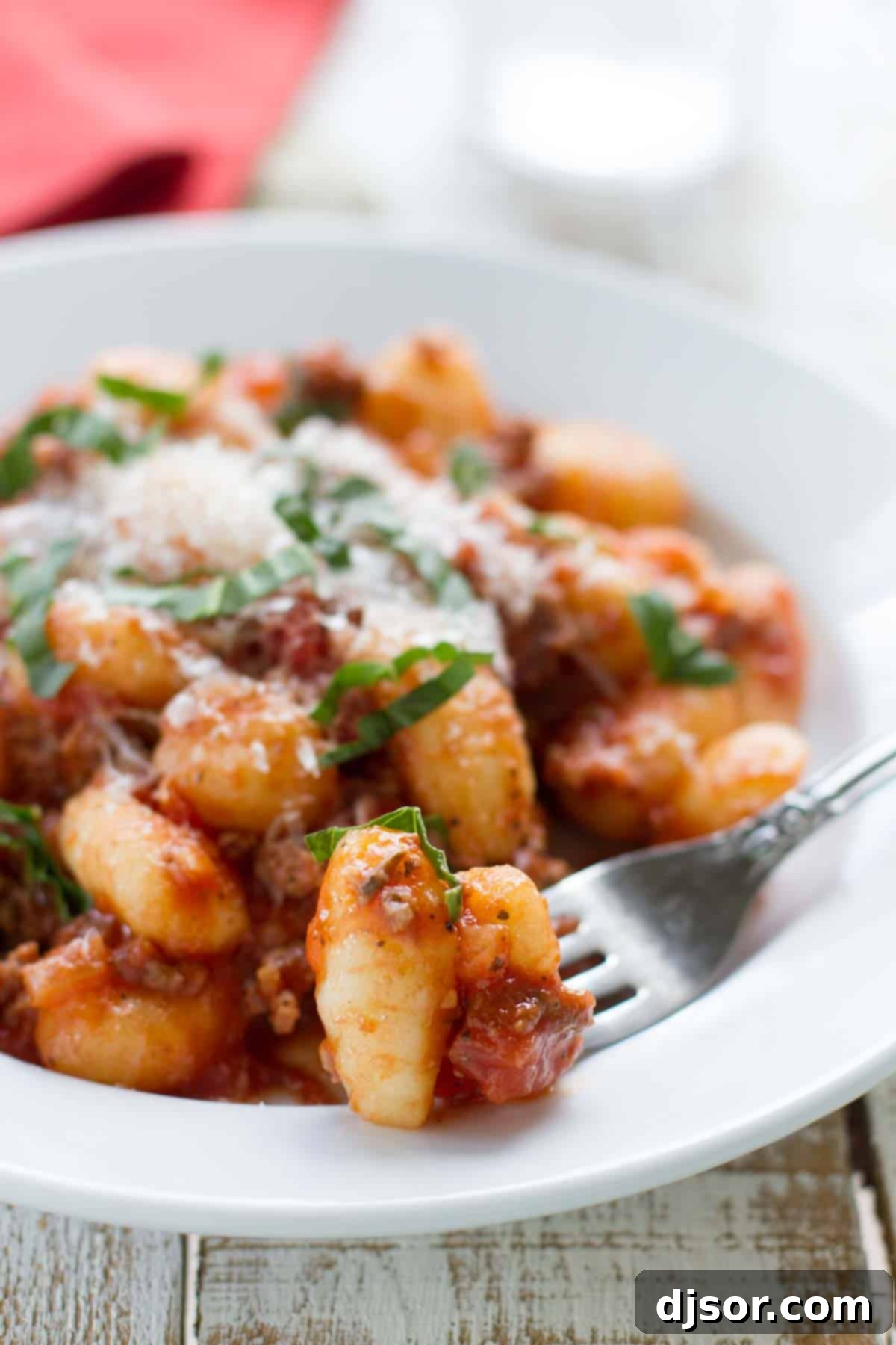 Pillowy Gnocchi with Rich Meat Ragu 4 Bowl filled with gnocchi with meat sauce with a gnocchi on a fork.