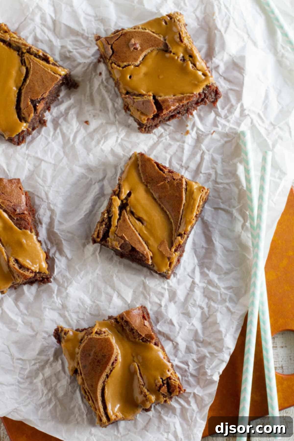 Lotus Biscoff Brownie Delight 3 Biscoff brownies set out on a piece of parchment paper, showing the beautiful swirl pattern.