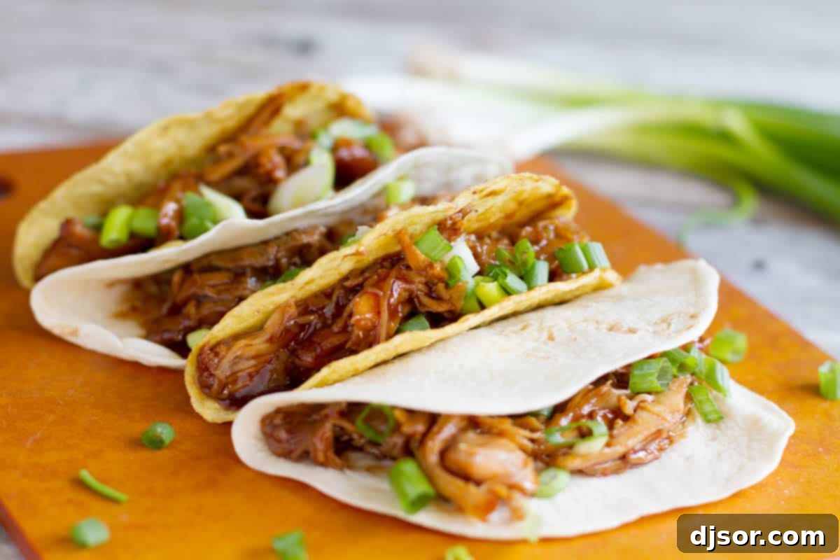 Honey Garlic Chicken Tacos with green onions on a cutting board.