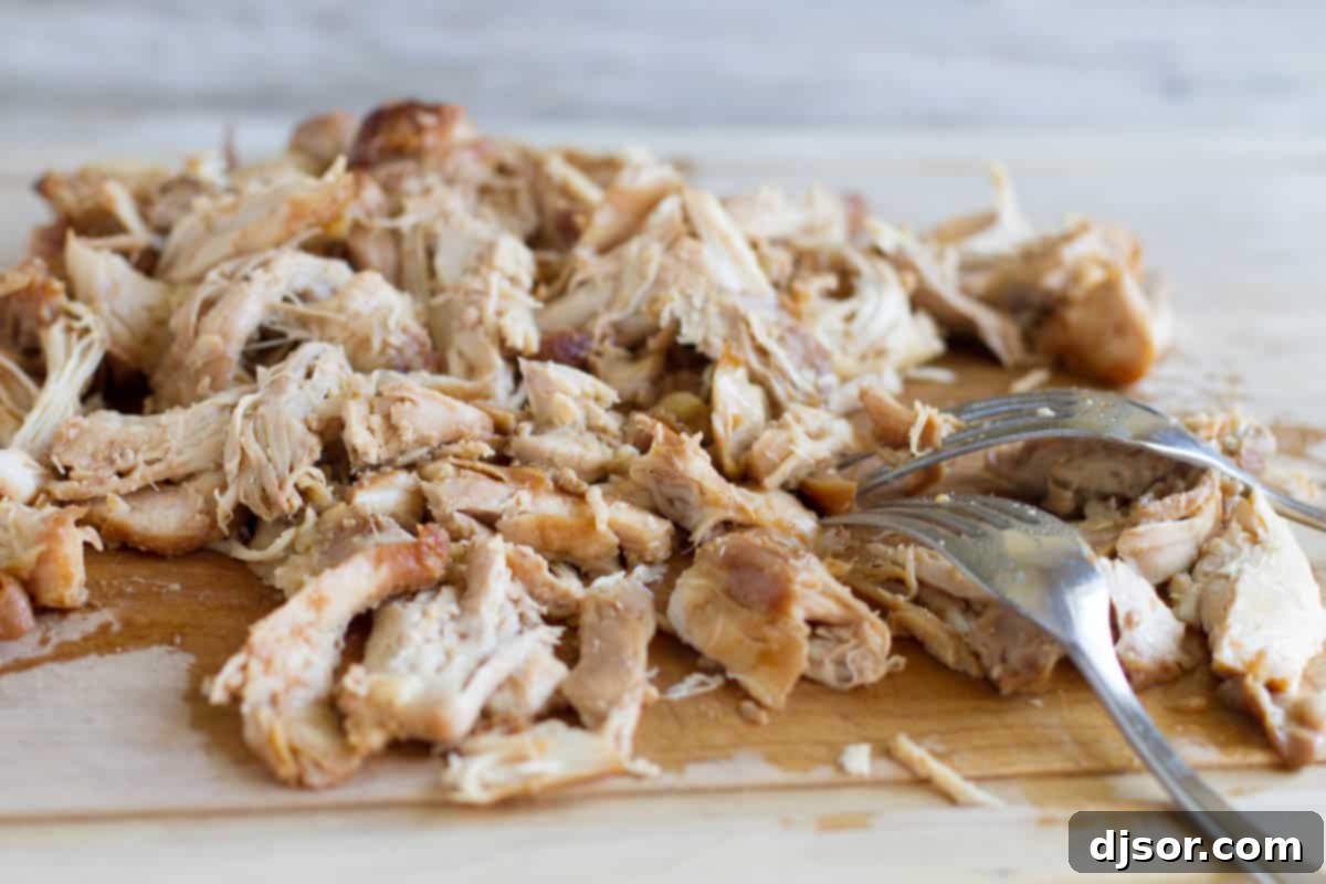 Shredding chicken thighs for Honey Garlic Chicken Tacos.
