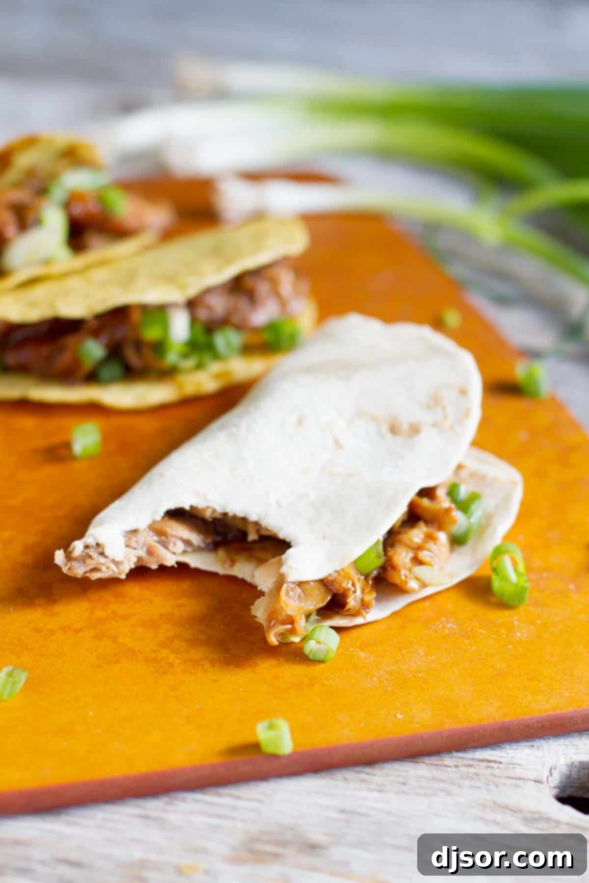 Honey Garlic Chicken Taco with a bite taken from it.