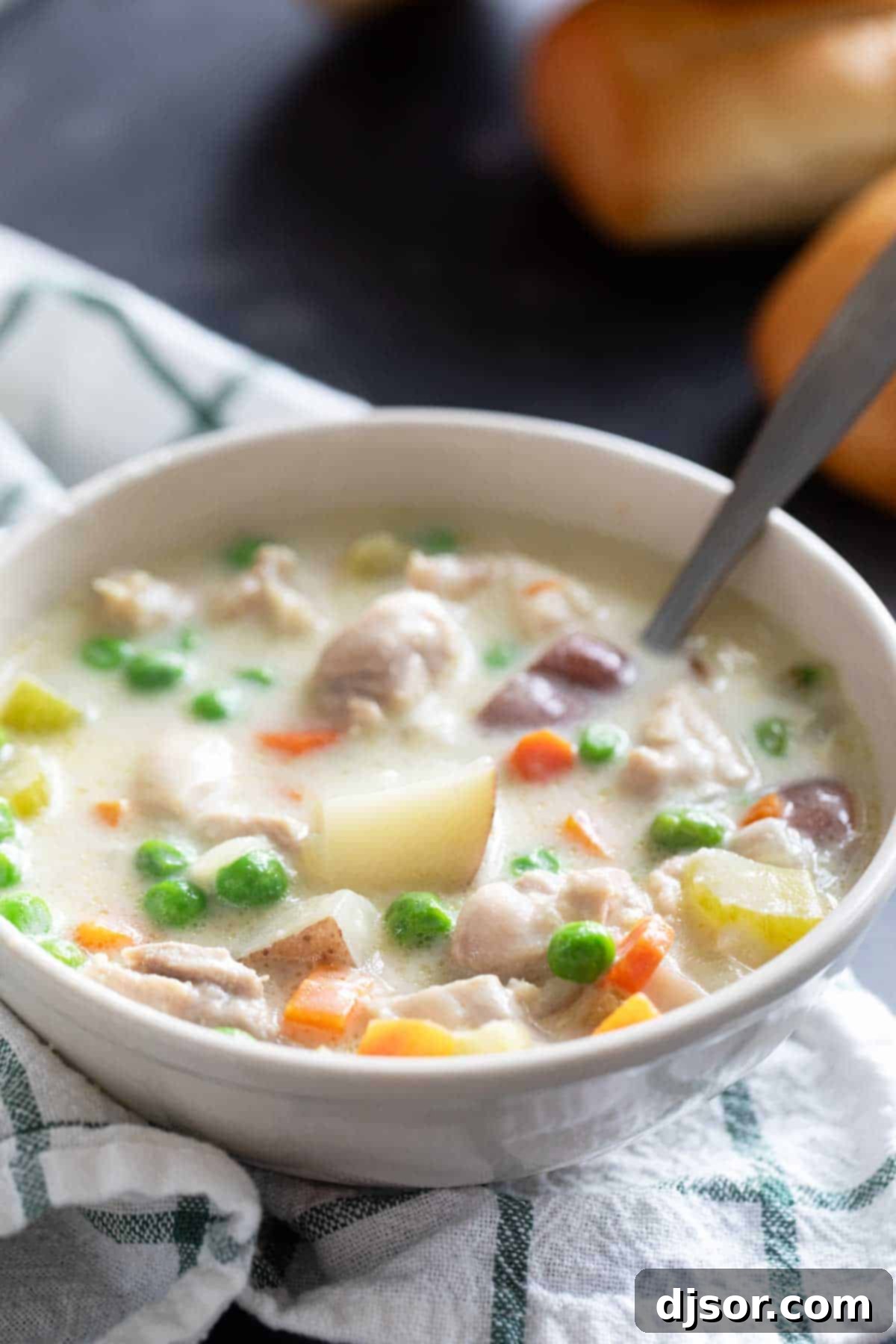 Hearty Chicken Stew 8 A close-up shot of a bowl of rich chicken stew with a spoon, highlighting the creamy texture, chunks of chicken, and tender vegetables, ready to be enjoyed.