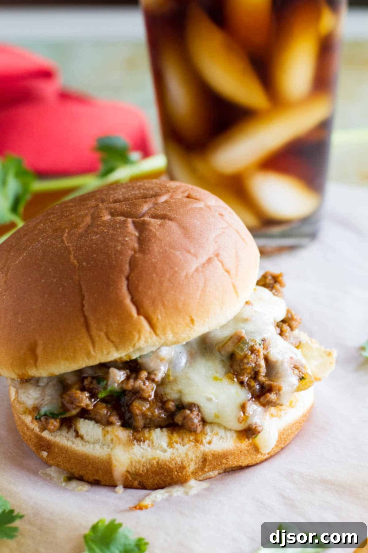 Enchilada Sloppy Joe Recipe: A Tex-Mex twist on classic comfort food. Delicious Enchilada Sloppy Joe sandwich with melted pepper jack cheese and cilantro, served on a toasted bun.