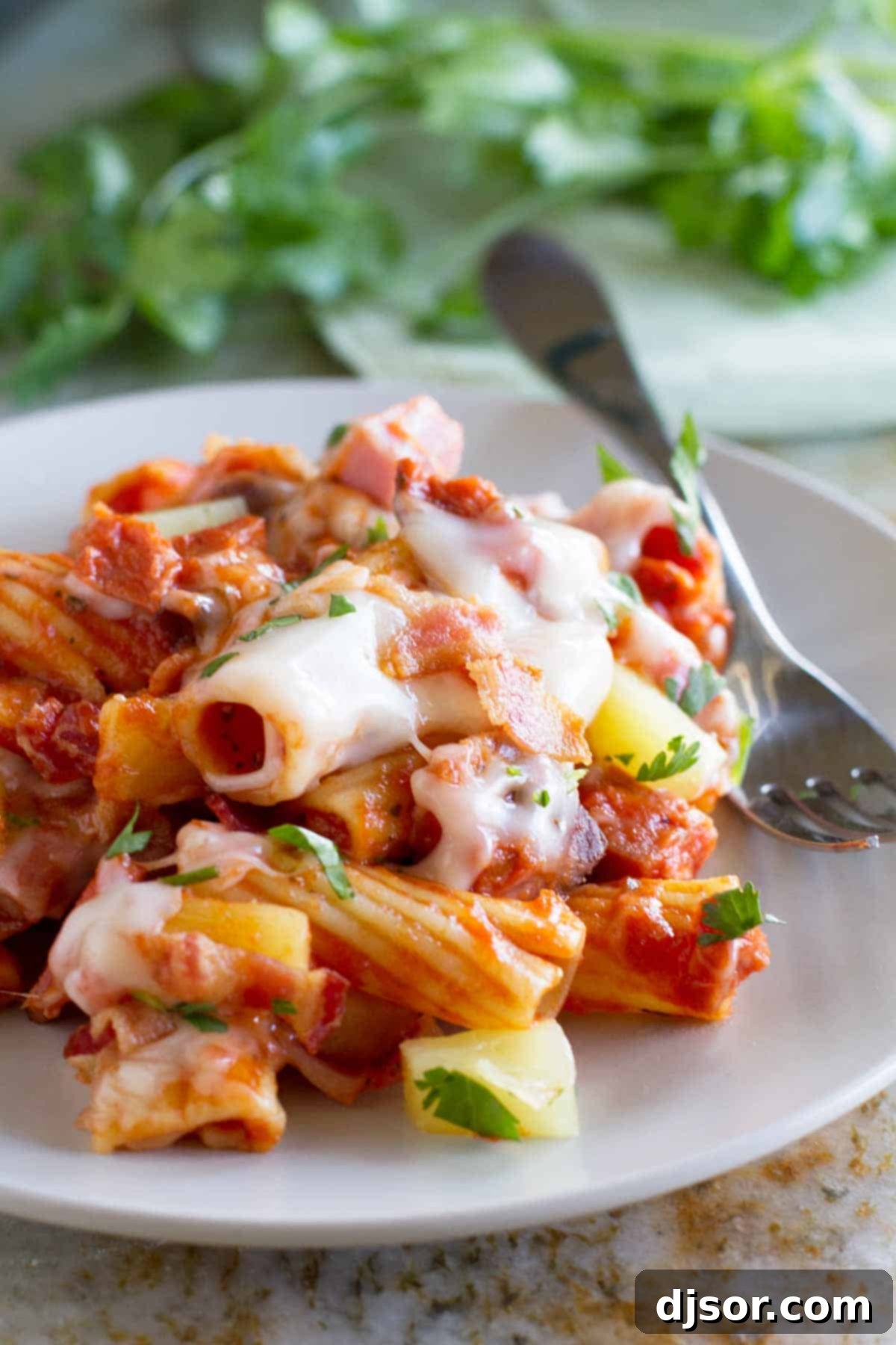 A perfectly portioned serving of Hawaiian One Pan Pasta on a white plate, showcasing the vibrant colors and appealing texture of the dish.