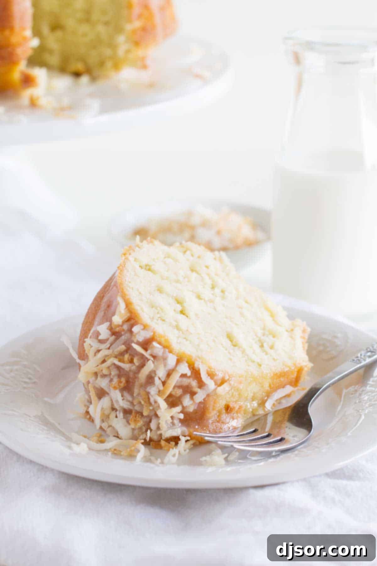 A perfect slice of coconut bundt cake resting on a plate, showcasing its fluffy texture.