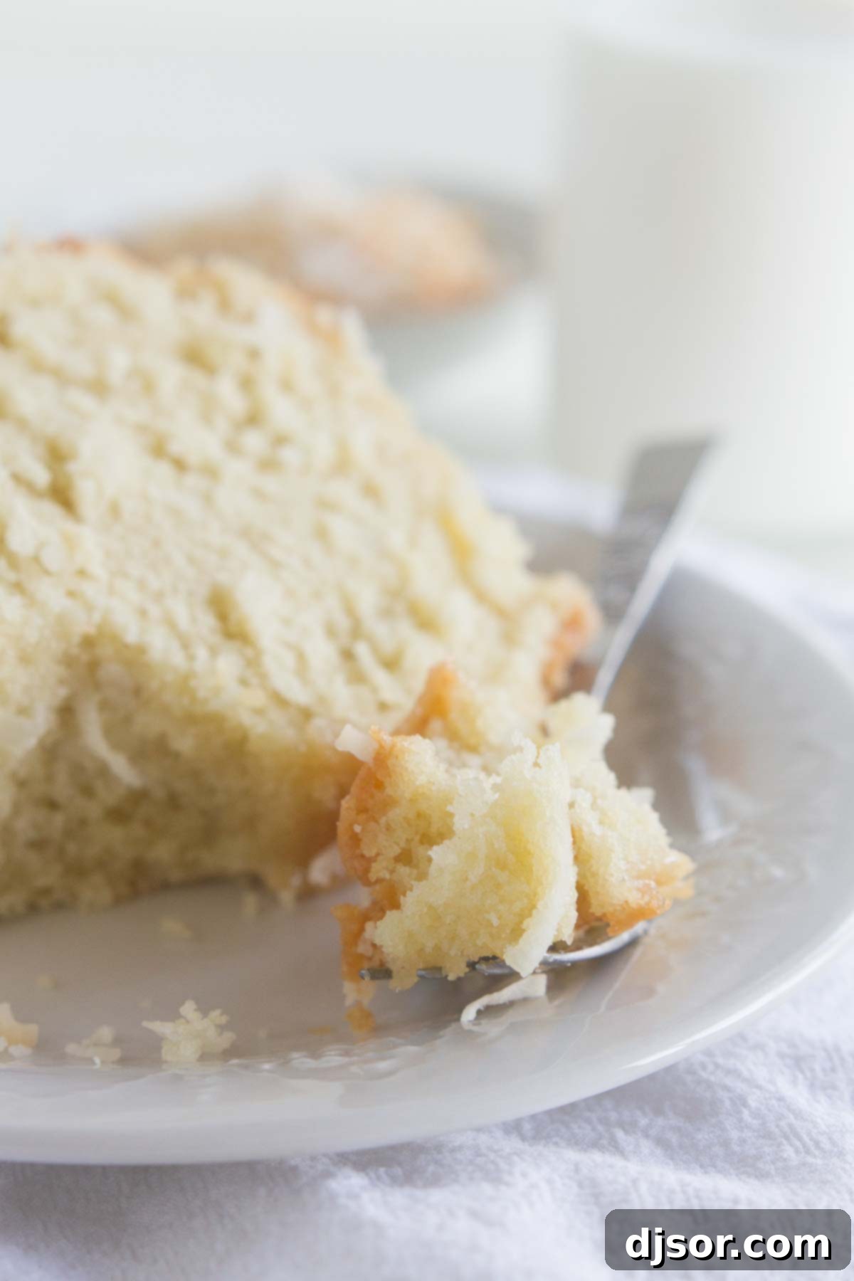 A forkful of moist coconut bundt cake, showing the perfect texture and delicious glaze.