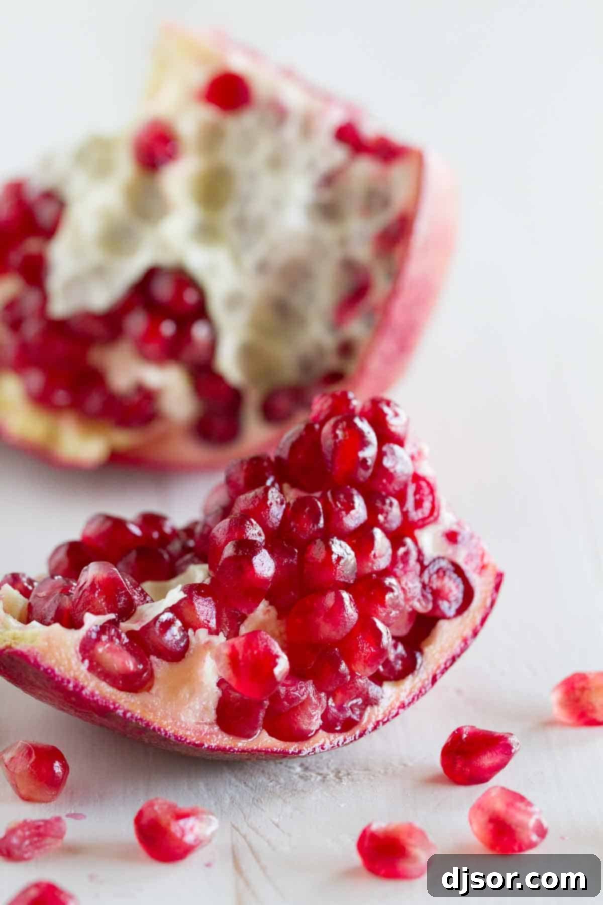 Close-up of a fresh pomegranate, cracked open to reveal its jewel-like seeds.