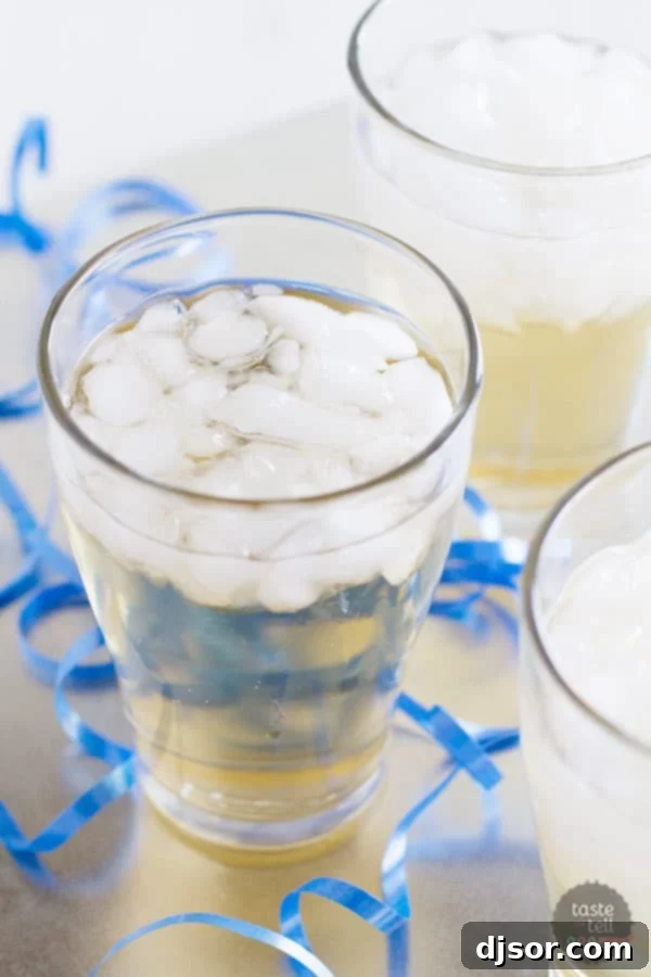 Close-up of a glass of holiday punch garnished with orange slices and cranberries, showing the refreshing texture.