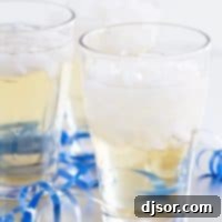 A beautiful glass of non-alcoholic Holiday Punch, garnished with cranberries and orange slices, ready for a party.