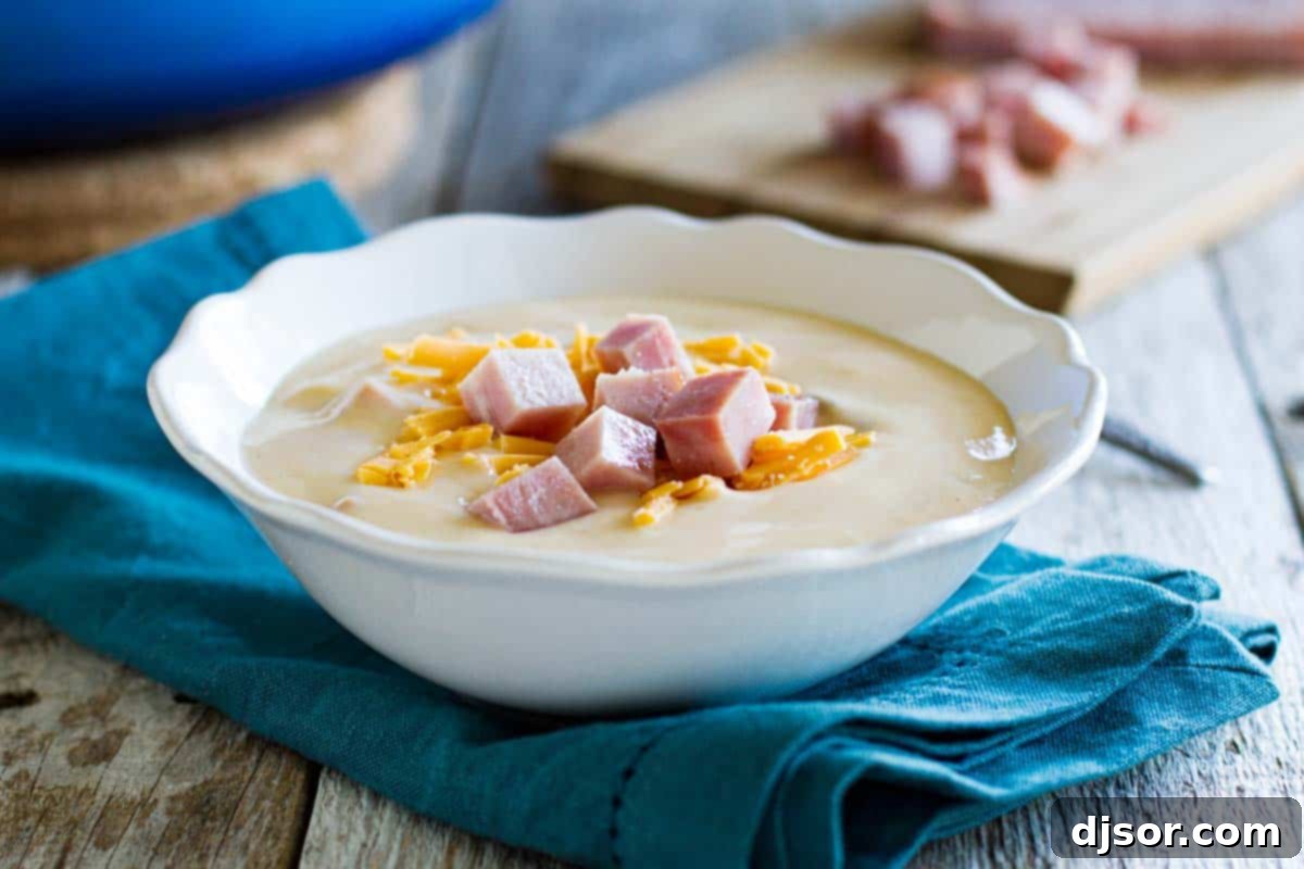 Creamy Cauliflower Soup with Ham and Cheese – A Hearty Comfort Dish bowl of ham and cauliflower soup, garnished with fresh herbs