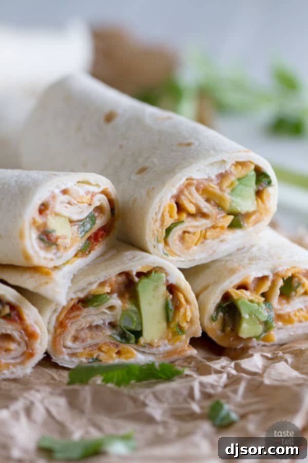 A perfectly rolled Vegetarian Wrap with Beans and Cheese, cut in half to show the vibrant layers inside, ready for enjoyment.