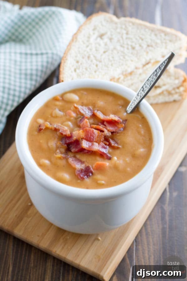 Hearty Bean and Bacon Soup 5 A close-up shot of homemade bean and bacon soup bubbling gently in a rustic Dutch oven, highlighting its rich, hearty texture and visible chunks of vegetables and bacon.