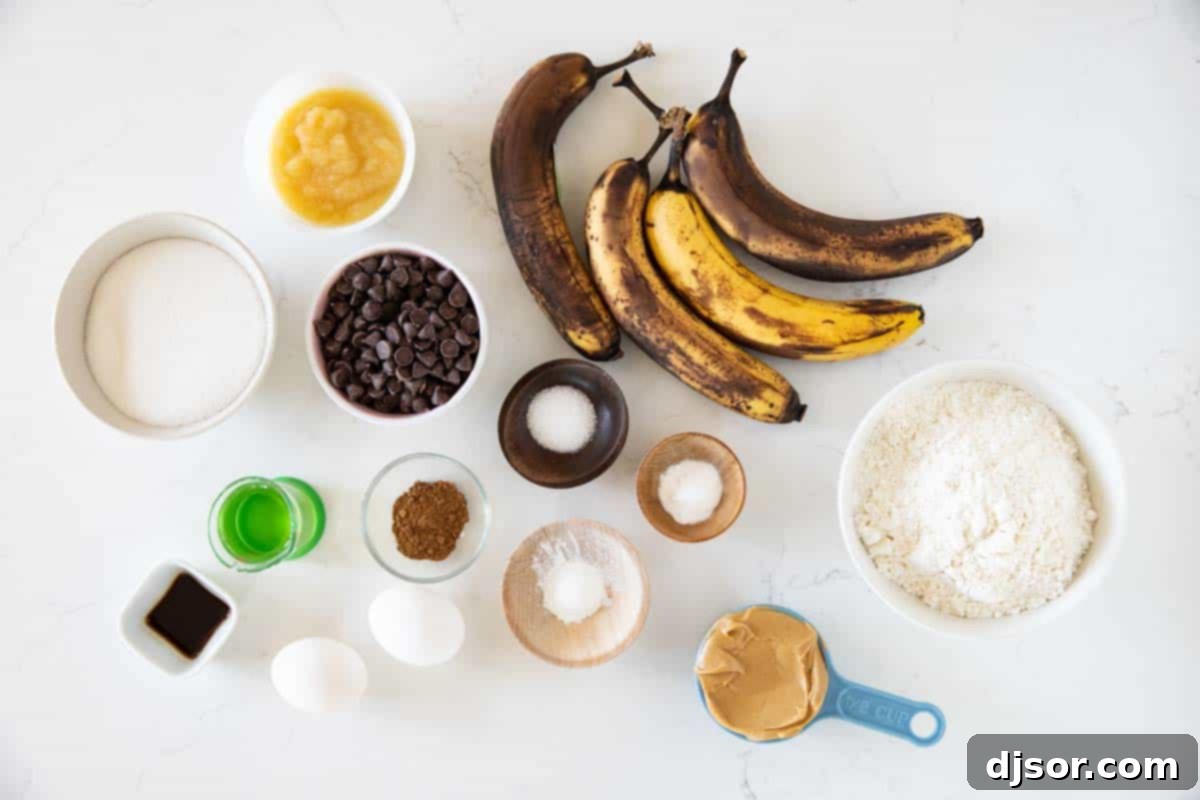 Fit for a king, this Peanut Butter Banana Bread with Chocolate Chips is a fun take on Elvis’ favorite flavor combination - peanut butter and bananas. A flat lay photograph showcasing all the fresh ingredients neatly arranged to make Peanut Butter Banana Bread with Chocolate Chips, including ripe bananas, flour, eggs, peanut butter, and a bowl of chocolate chips.