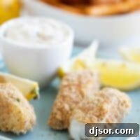 Close-up of a perfectly cooked, flaky fish stick with a crispy exterior.