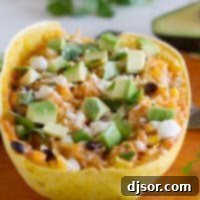 A perfectly cooked half of spaghetti squash, generously filled with a robust mixture of black beans, corn, rich enchilada sauce, and melted cheese.