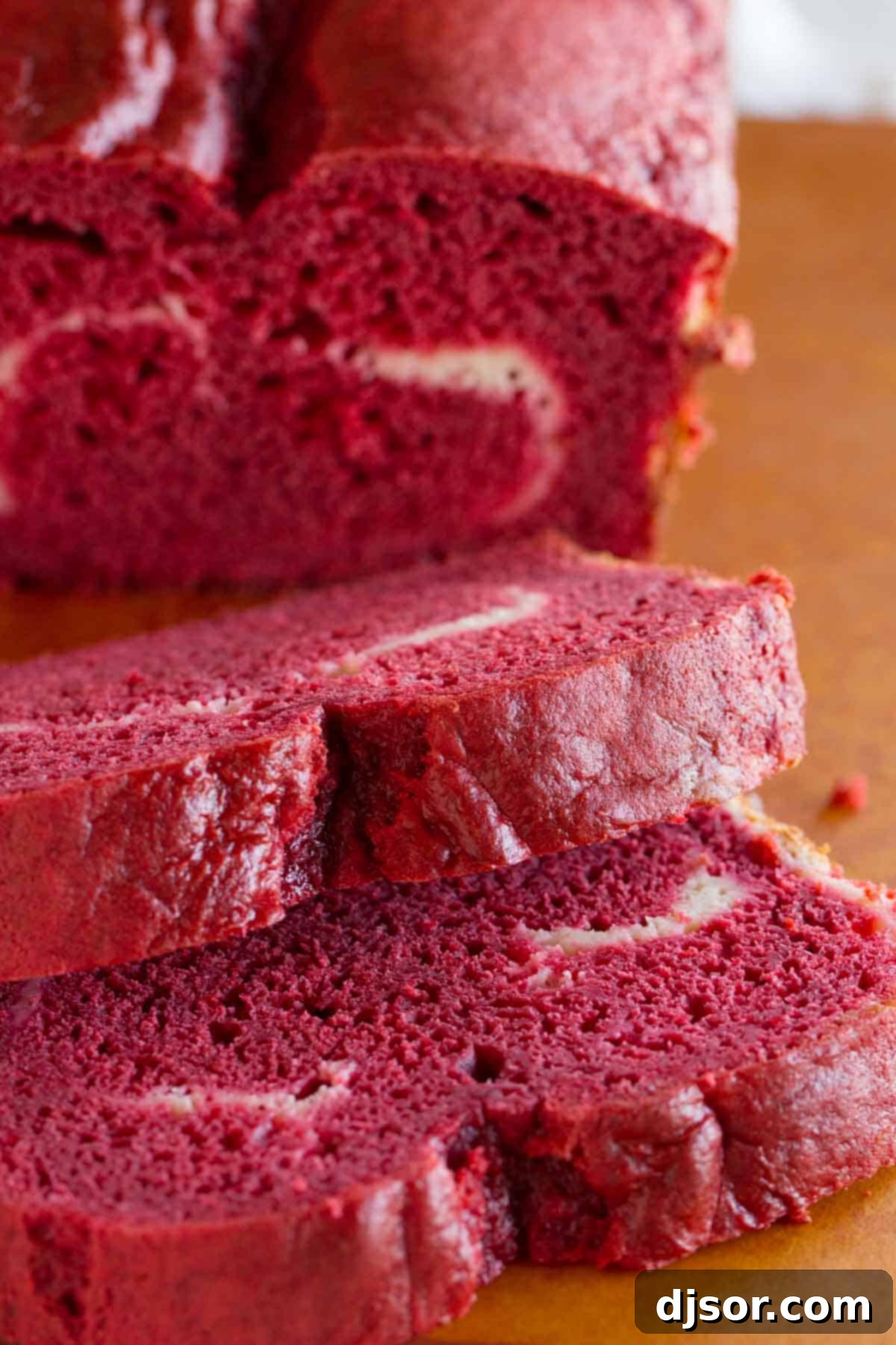 Slices of red velvet quick bread showing the moist texture and vibrant color.